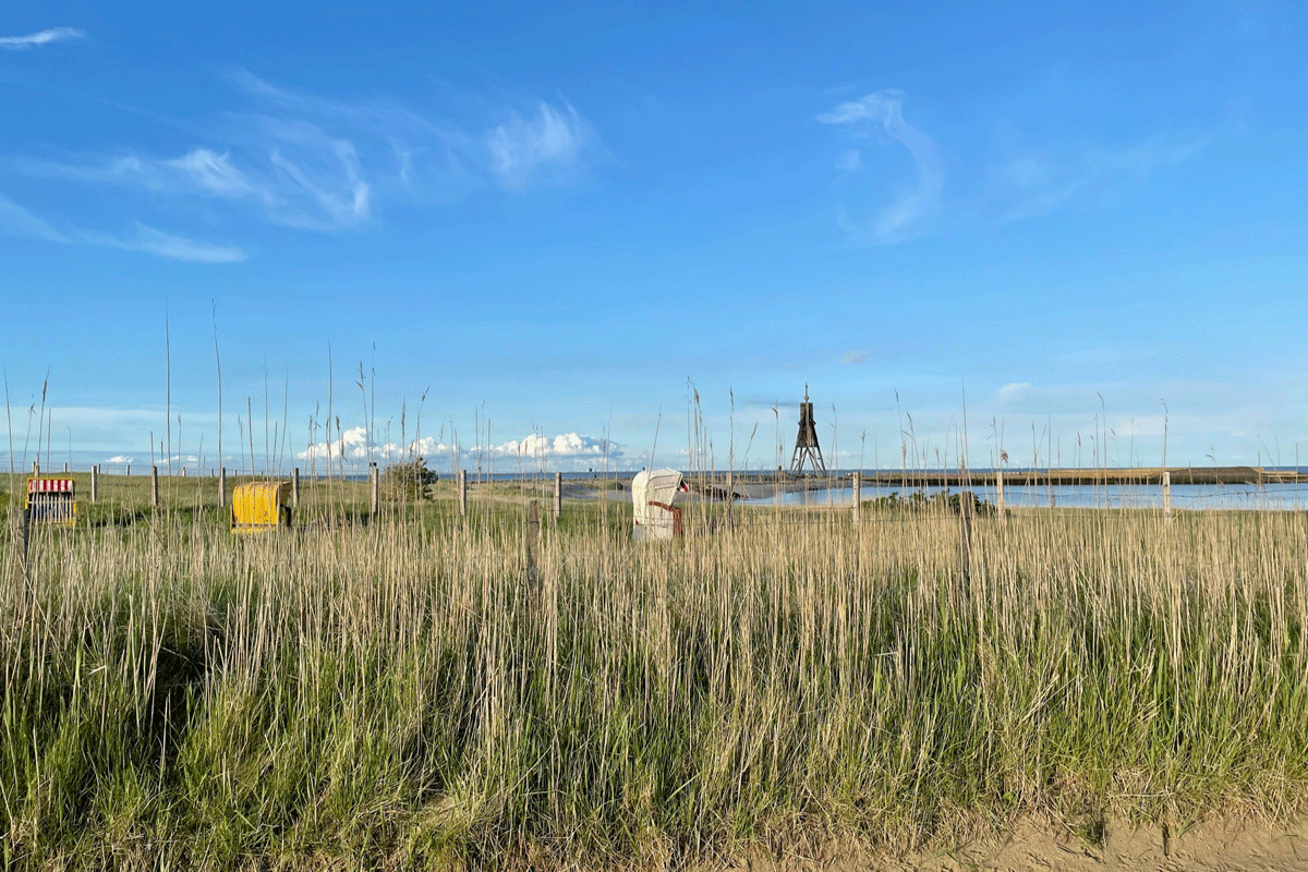 Vereinzelte Strandkörbe hinter Dühnen an der Nordsee